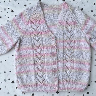 Beautiful hand knitted lacy pattern cardigan in shades of pink and white with a hint of twinkel for that extra special appeal V- neck 7 Beautiful pink buttons in front Long sleeves Ribbing around neckline, cuffs and hem 100% Acrylic yarn Completed garment measurements Chest all around: 68cm Length, shoulder to hem ribbing: 37cm Sleeve seam length: 22cm