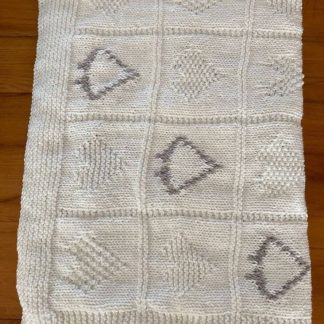 Hand knitted baby’s blanket in white with varied heart motives in white and accents of grey. Wonderfully soft to the touch. Keeps your little one warm and snug. Crafted with care using high quality yarns. 50% cotton 50% Acrylic Length: 110cm Width: 110cm